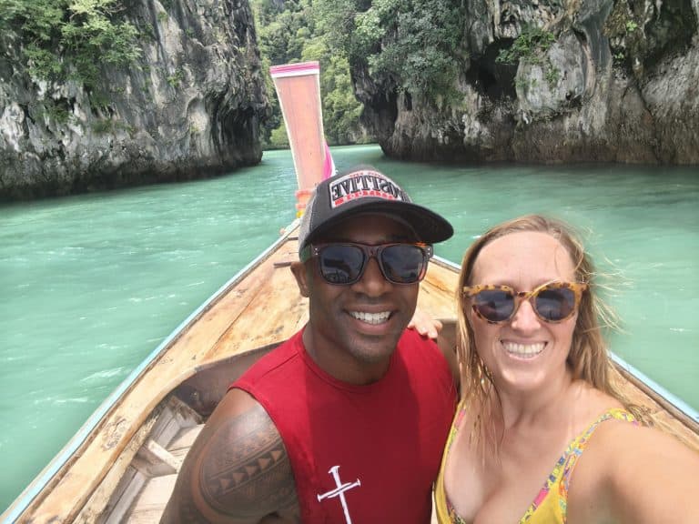 Jason and Steffi on a longtail boat in Thailand with the turquoise Andaman sea behind